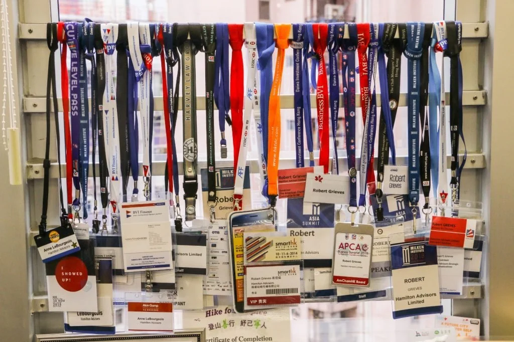 Pile of traditional event badges and lanyards, illustrating the waste generated by non-sustainable materials compared to Terra Tag’s plantable and recycled alternatives