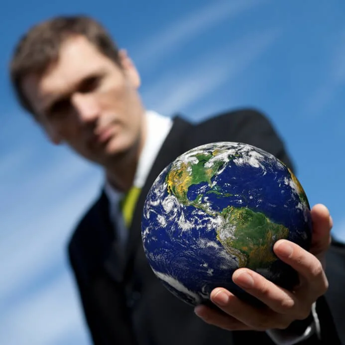 Man holding a model of the Earth, representing a sustainability manager overseeing eco-friendly practices and the use of Terra Tag’s plantable and recycled name badges at events