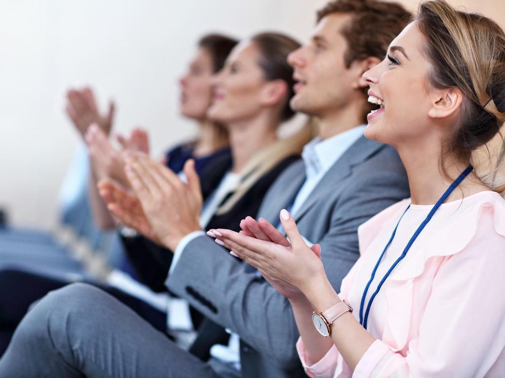 Audience applauding at a conference, highlighting Terra Tag’s plantable and recycled name badges as the best choice for professional and sustainable events
