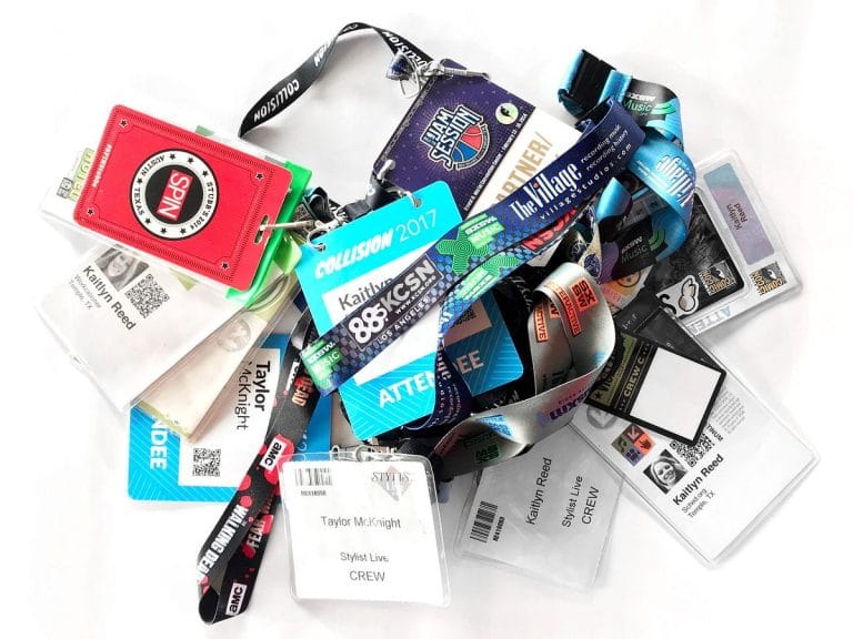 Pile of plastic name badges with synthetic lanyards before switching to eco-friendly alternatives to plastic name tags by Terra Tag