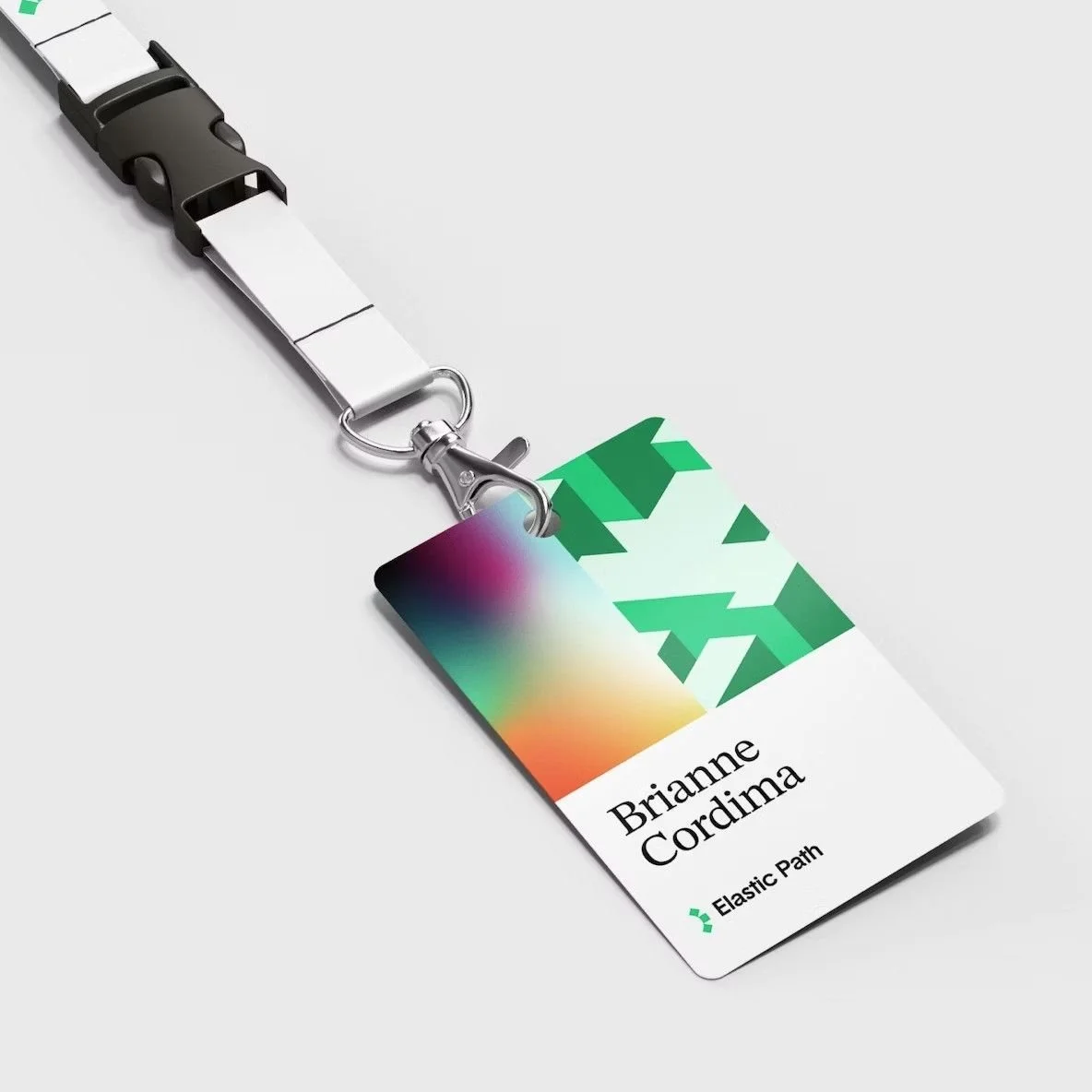 Conference name badge on a lanyard with a green brand graphic across the top and the name below it