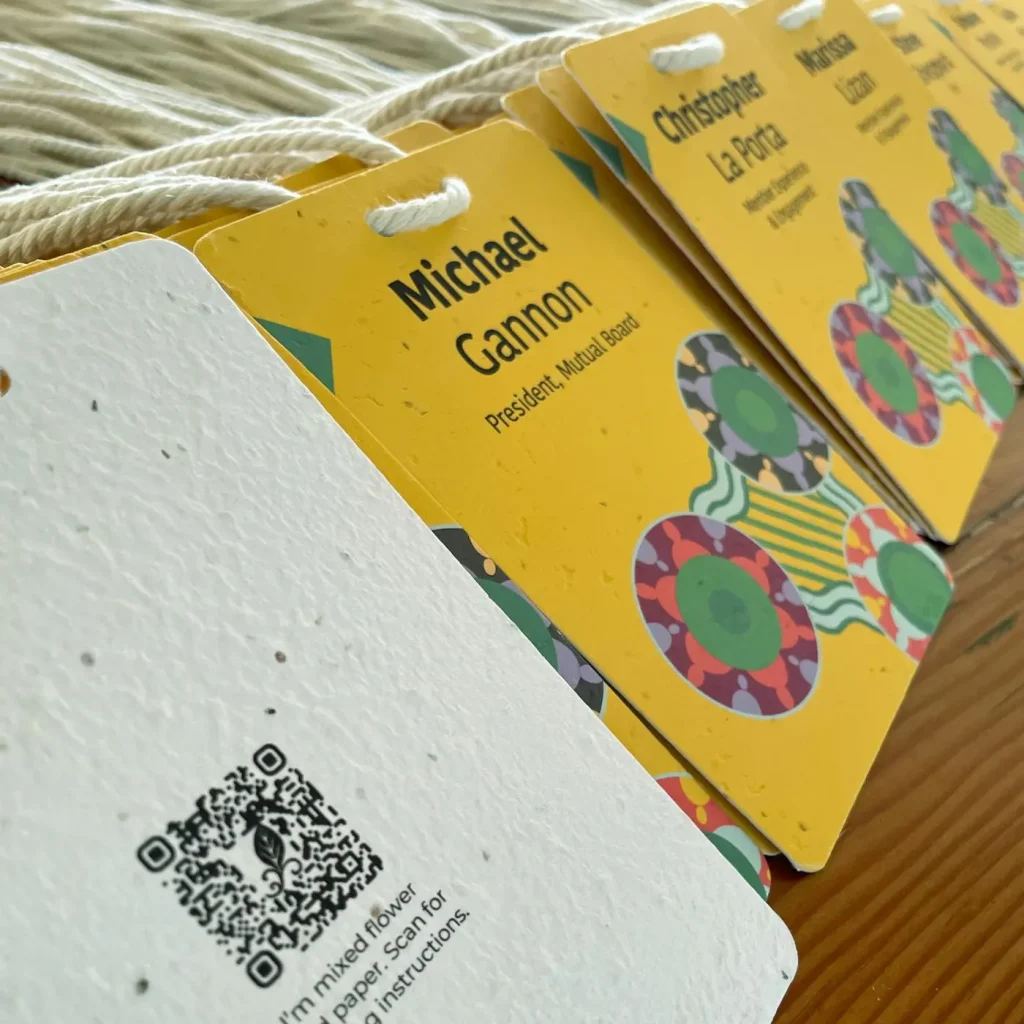 Plantable seed paper name badges with QR codes, assembled with biodegradable cotton lanyards.