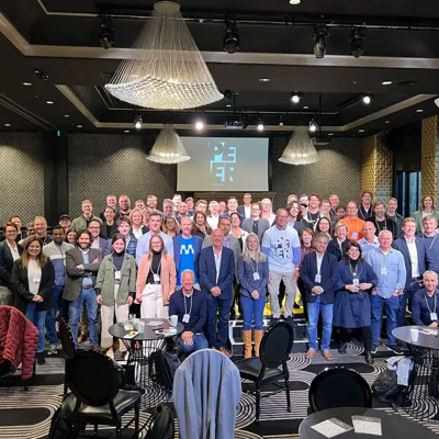 Event attendees wearing recycled paper name badges during an corporate event, showing consistent print quality and natural cotton lanyards.