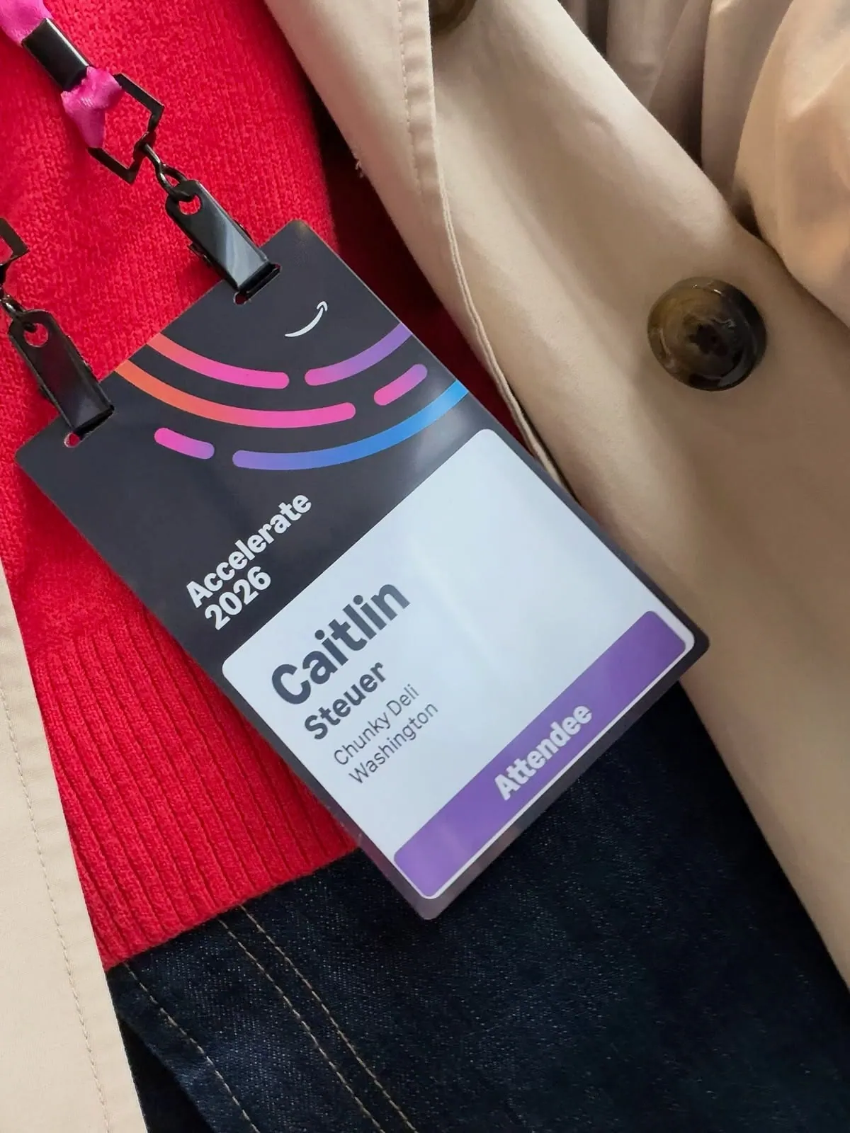 Large conference badge worn on a lanyard, with the name, organisation and an Attendee role band
